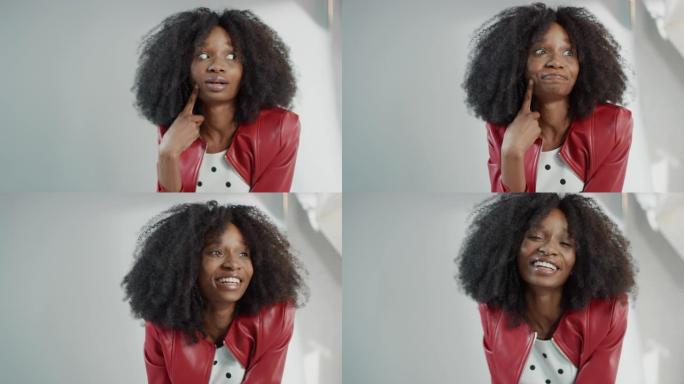 迷人的黑人女孩，郁郁葱葱的卷发摆姿势拍摄时尚杂志照片。傻瓜带着深思熟虑的表情。为时尚杂志拍摄专业工作