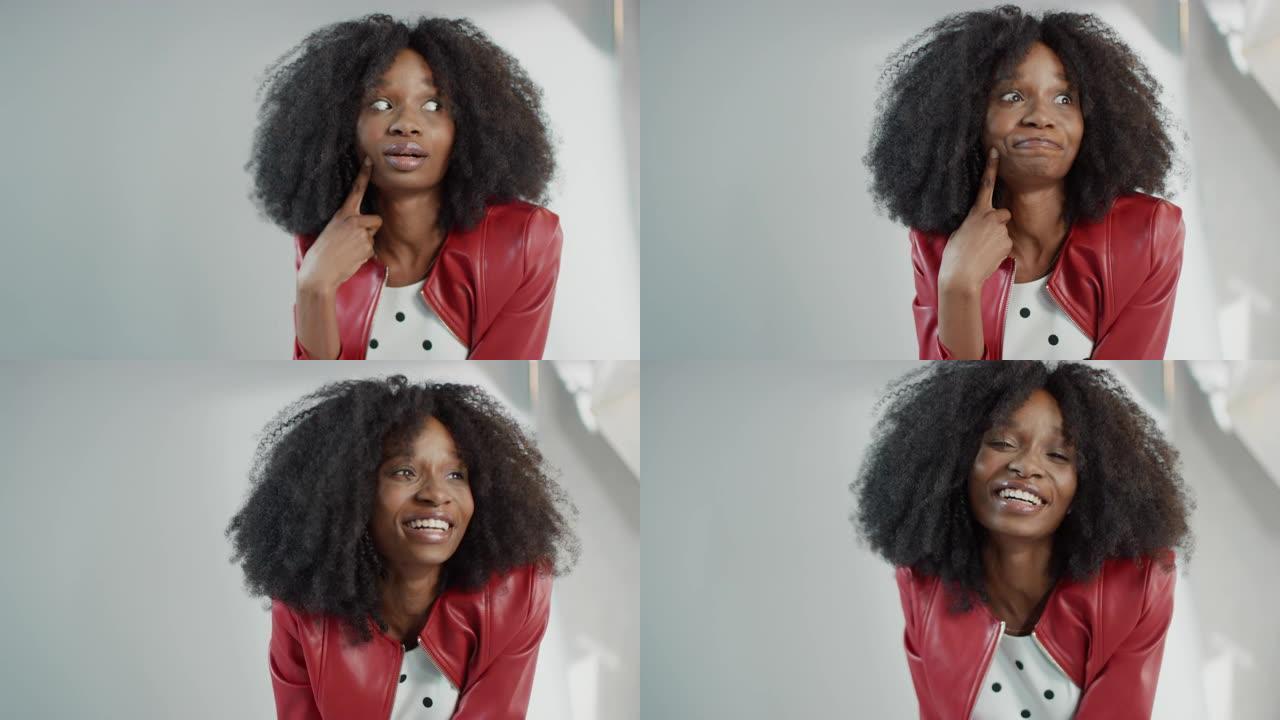 迷人的黑人女孩，郁郁葱葱的卷发摆姿势拍摄时尚杂志照片。傻瓜带着深思熟虑的表情。为时尚杂志拍摄专业工作
