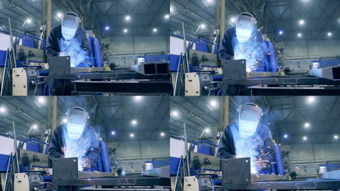 戴着防护面罩的男性焊工正在加工金属。专业重工业焊工在工厂工作。