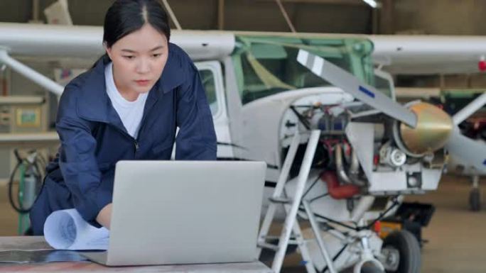 领导亚洲少女在机库飞机上使用开发工程师的计算机。STEM，技术，科学，创新，领导力，赋权，专业知识，