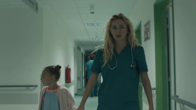 护士和女孩走过医院走廊