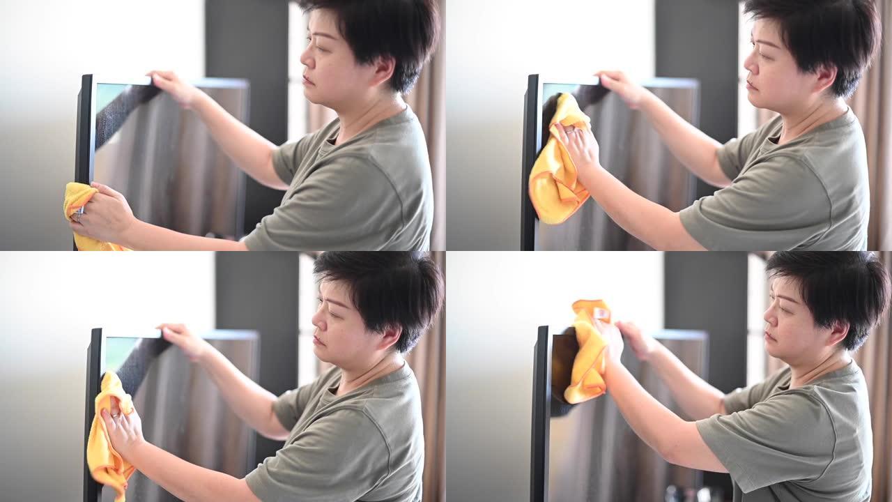 一名亚洲华裔女性用超细纤维布擦拭电视
