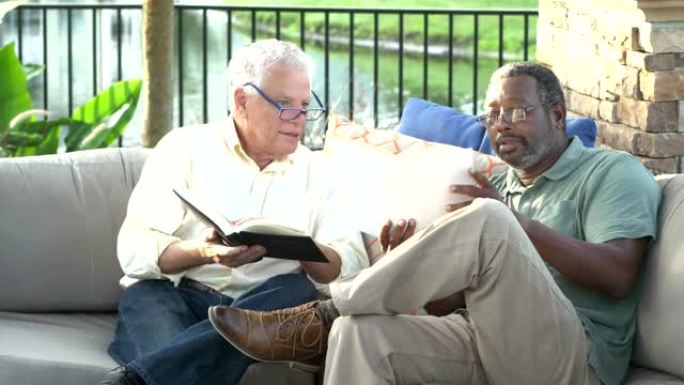 两个多民族的男人在露台上看书