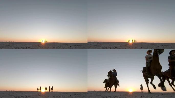 一群骑马者的慢动作低角度视图，在日落时分在Makgadikgadi盐锅的广阔空间中奔跑