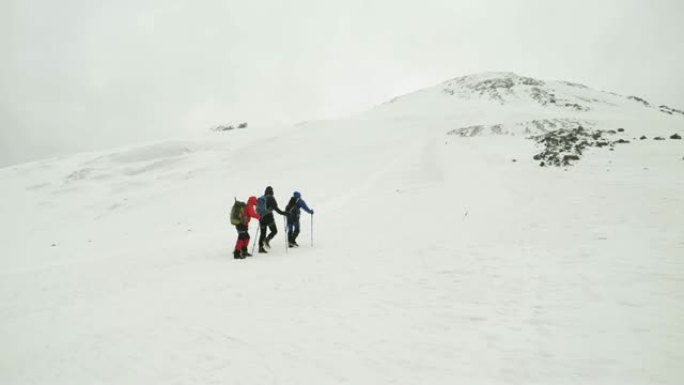 徒步旅行团体走在山上的雪道上