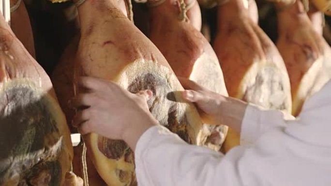 在一家火腿工厂中，一名负责质量控制的人在火腿和控制，香水和经过认证的意大利品质之间行走。