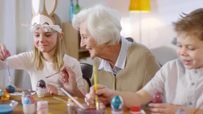 可爱的孩子和祖母画鸡蛋