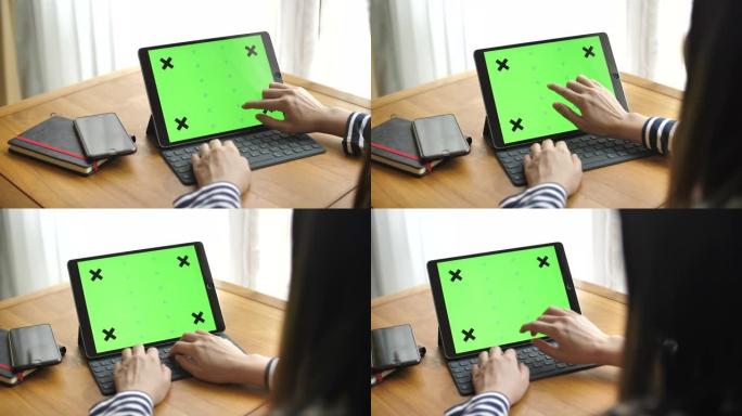亚洲妇女使用带有绿屏的笔记本电脑
