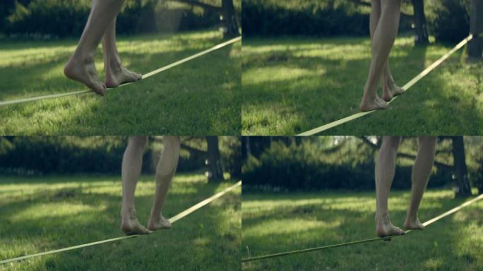 男子赤脚在松懈线上平衡。公园的夏天下午