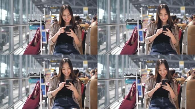亚洲妇女在机场使用社交媒体进行交流