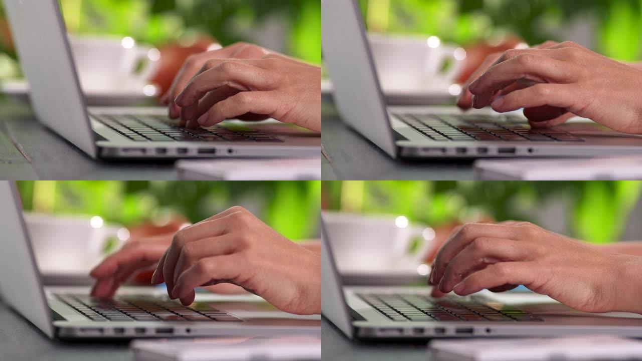 女性手指按下笔记本电脑的按钮，女性打字，在家或办公室工作。UHD滑动镜头