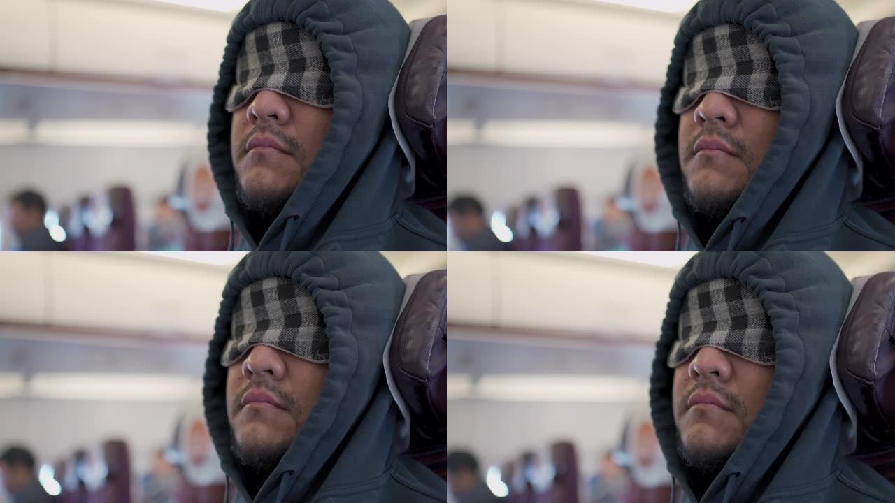 特写镜头男子戴着眼罩睡眠面罩在飞机上睡觉