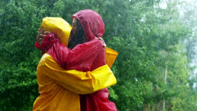 一对情侣，恋爱中的男人和女人在大自然的雨中跳舞，亲吻和玩耍快乐的微笑。自由和爱。