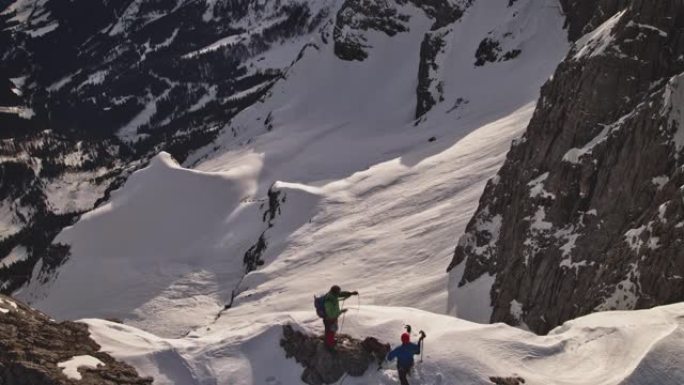 登山者在白雪皑皑的山上盘绕绳索