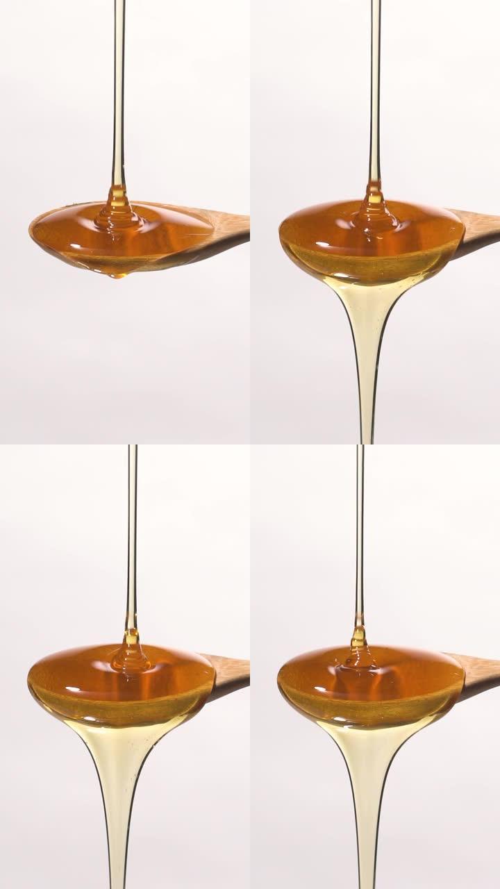 (慢动作和垂直) 从木勺上掉下来的蜂蜜