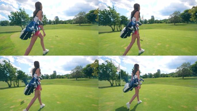 带着高尔夫配件的年轻女士正沿着草坪散步