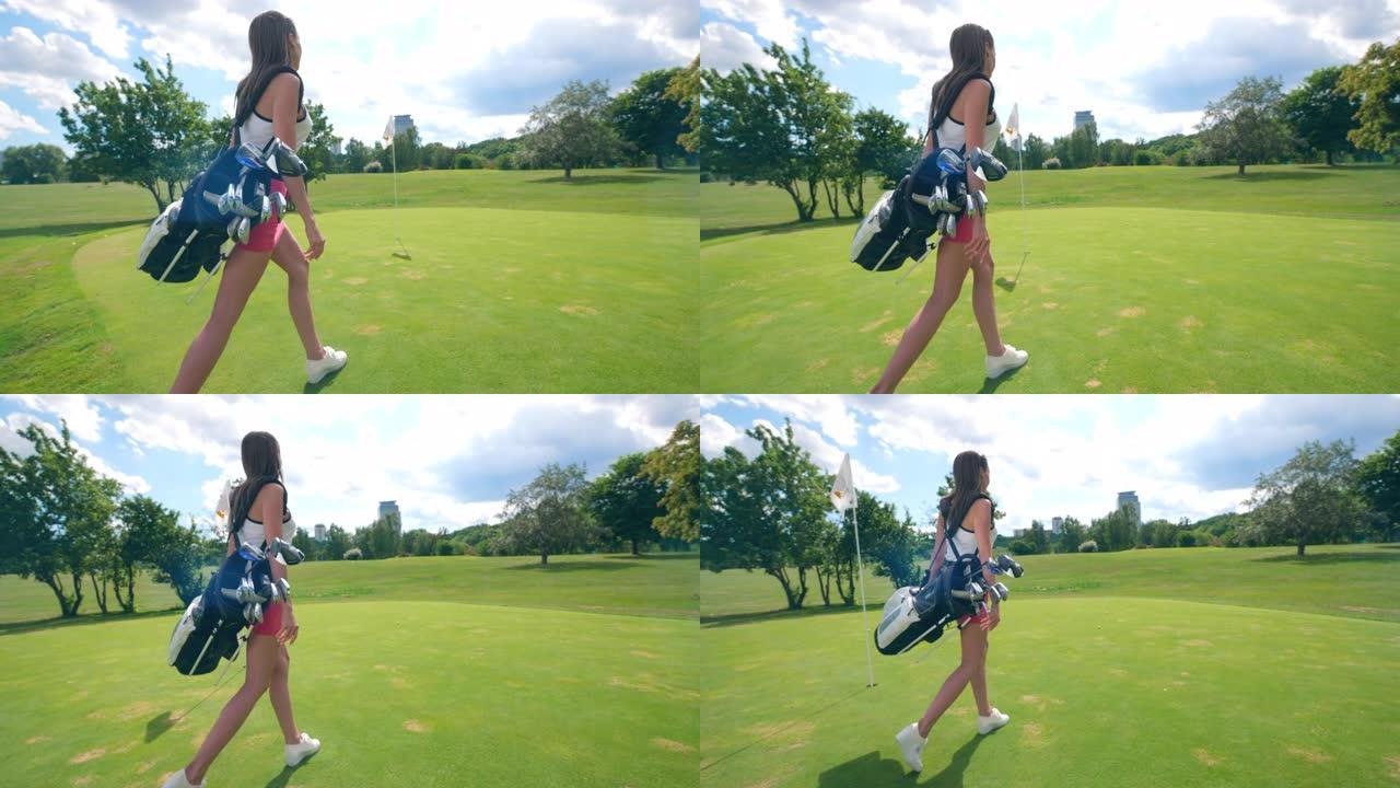 带着高尔夫配件的年轻女士正沿着草坪散步