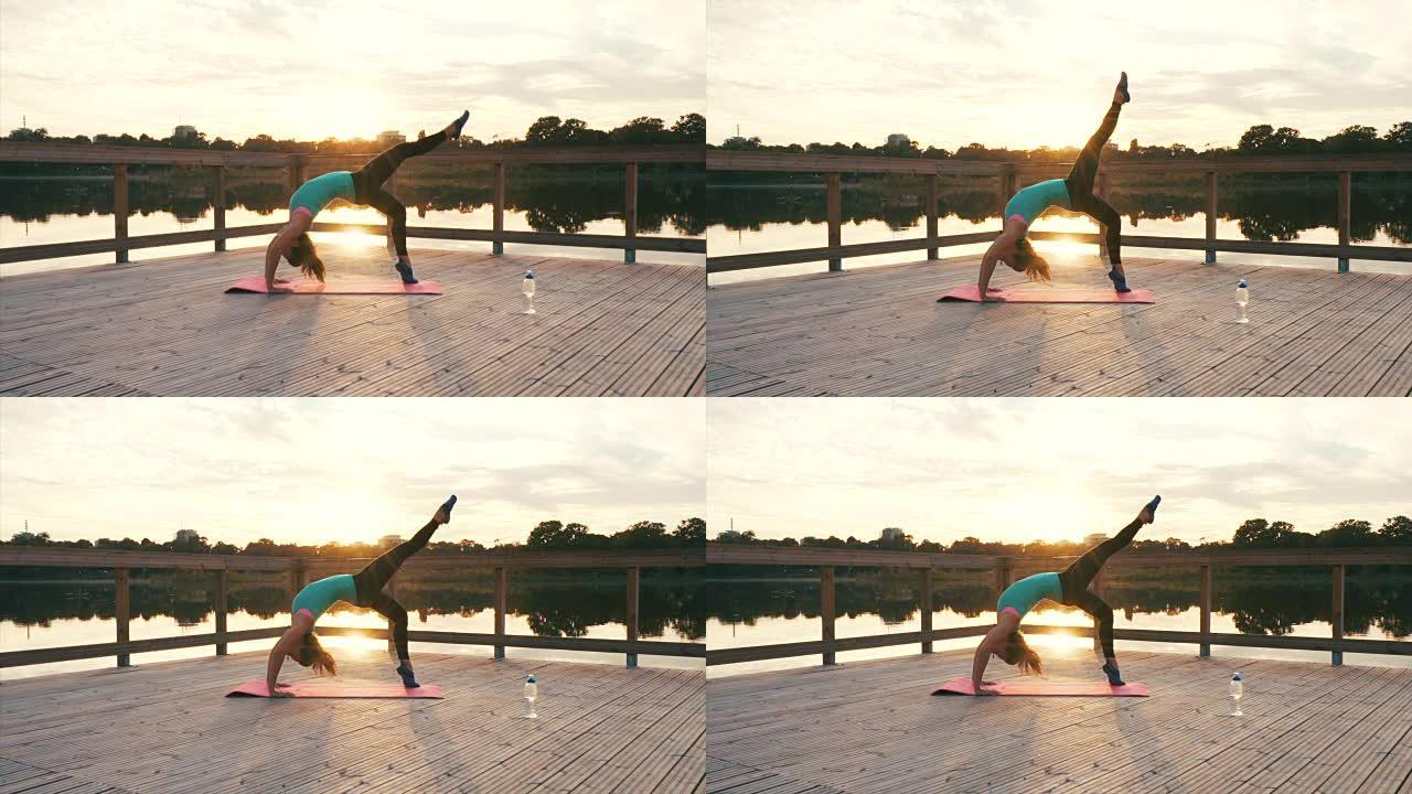 练习肌肉柔韧性。户外瑜伽健身健康美女湖边