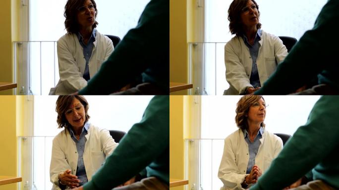 高级医生在诊所与她的病人交谈