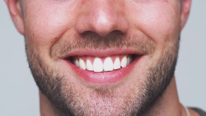 在工作室里，牙齿完美的男人在镜头前微笑