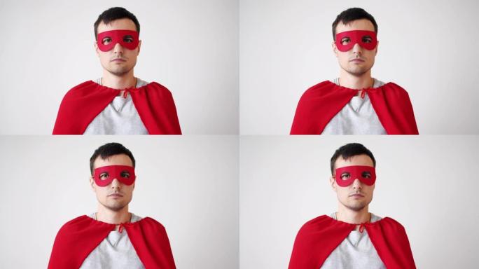 穿着超人服装的年轻人的肖像红色面具和斗篷看着相机
