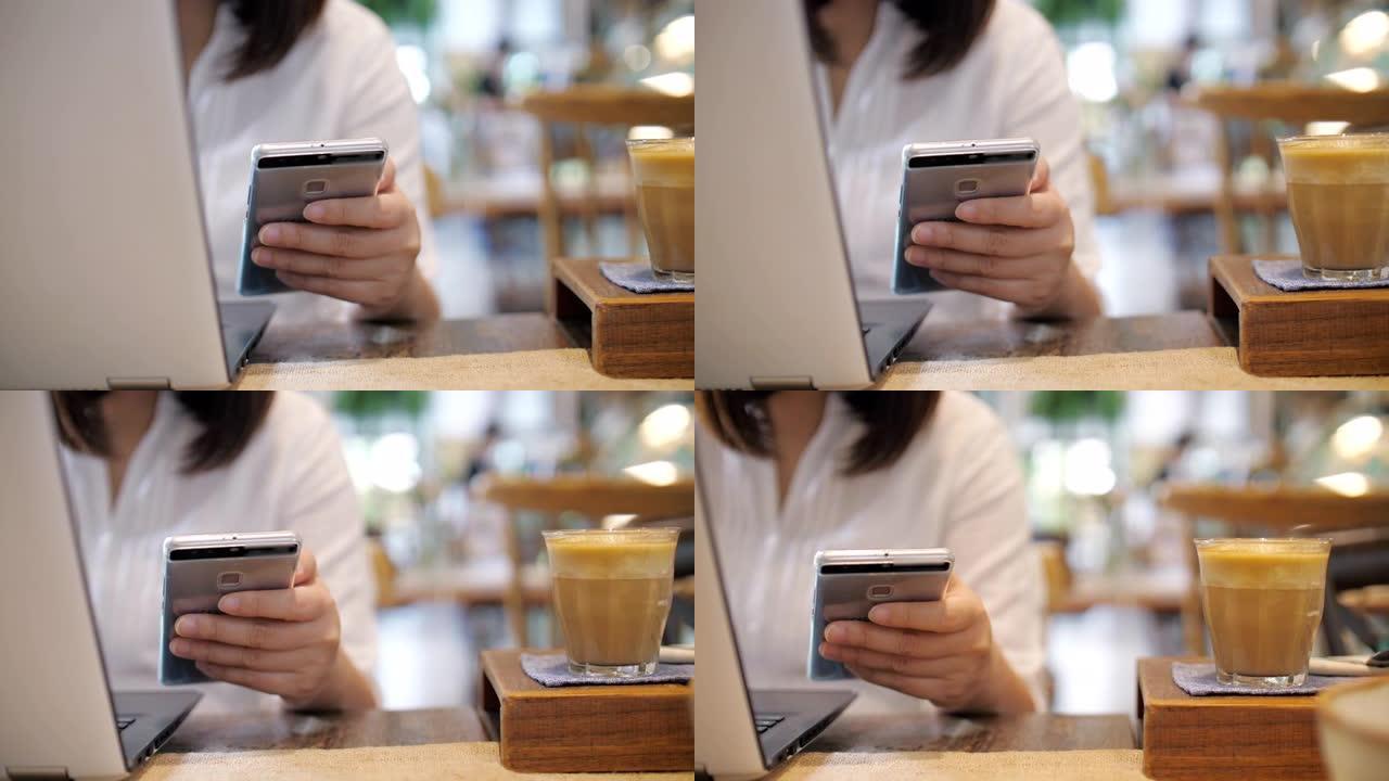 女人用笔记本电脑工作，在咖啡厅使用手机，慢动作