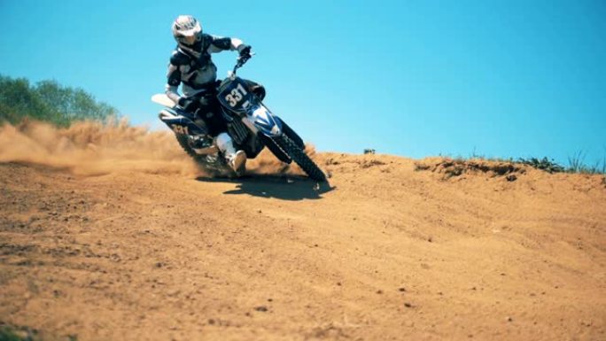 Sportbike的驾驶员正在曲折地穿越肮脏的地形。慢动作