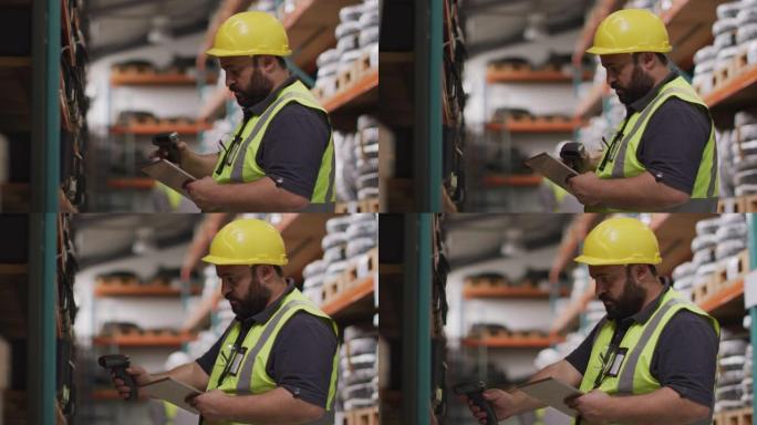 高加索男性工厂工人在工厂里戴着安全帽和高背心，检查库存