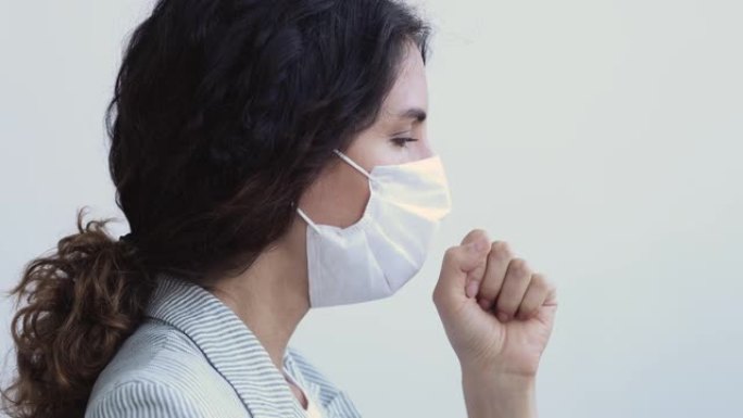 生病的年轻成年妇女戴着医用口罩咳嗽