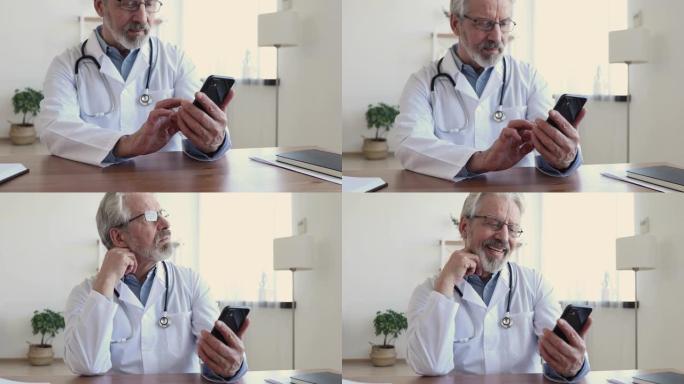 快乐的高级男医生在工作场所使用智能手机应用程序大笑