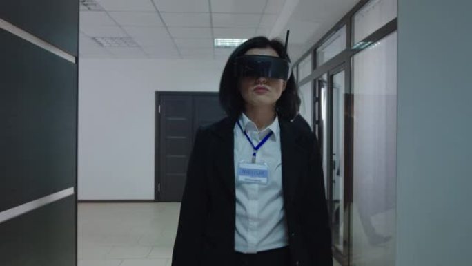 在办公室走廊中使用VR眼镜的女企业家