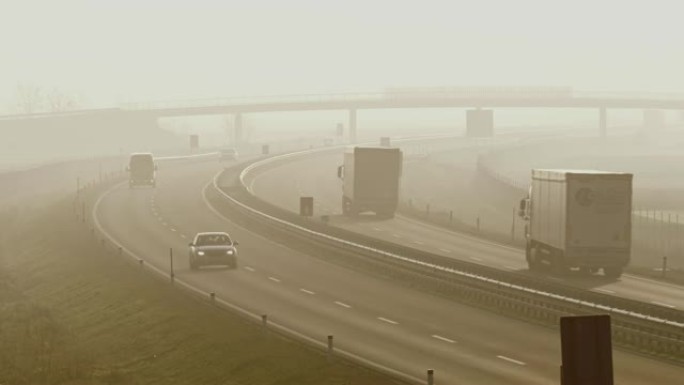 沿着有雾的高速公路行驶的MS汽车和卡车