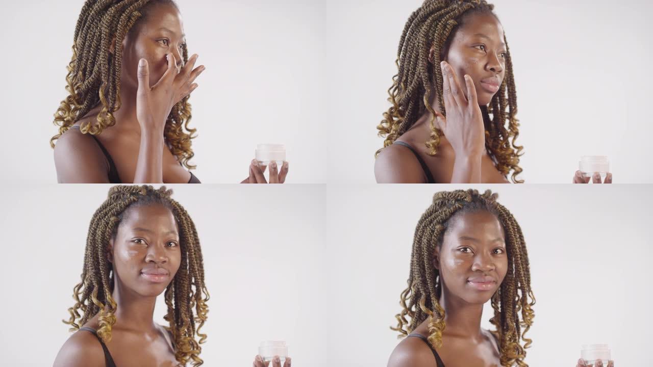 美丽的黑人女人在脸上涂上奶油