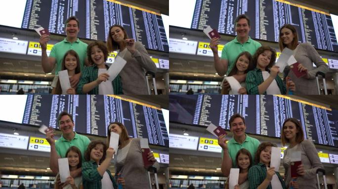 激动的家人准备在机场旅行，拿着登机牌和护照看着相机微笑