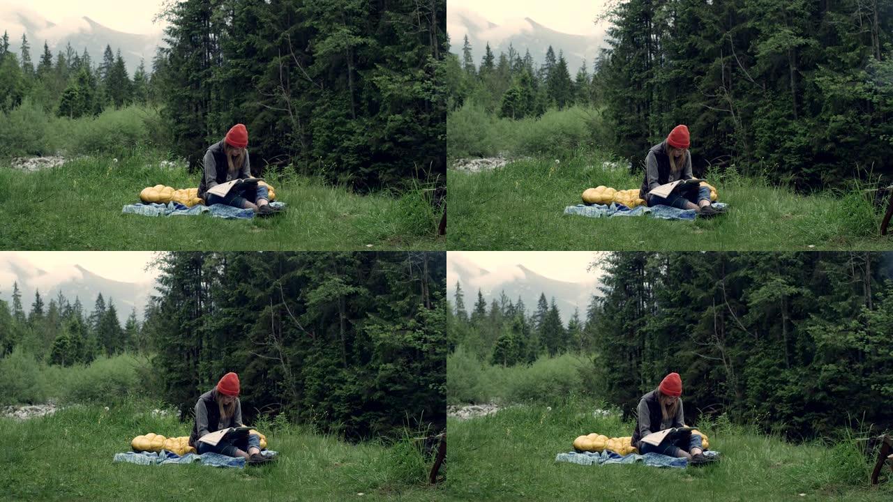 在野外露营。女人在草地上读书