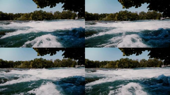美丽的绿树在尼亚加拉危险汹涌的快速河水上的特写镜头，泡沫溅到急流上。
