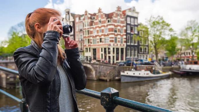 快乐的女人潮人游客在阿姆斯特丹度假，用复古相机拍照