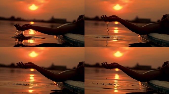 日落时在冲浪板上放松时，超级SLO MO女人用手舀水