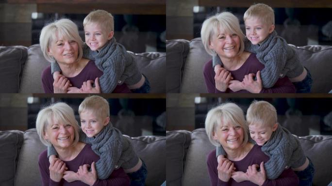 一个祖母和孙子依偎在沙发上。