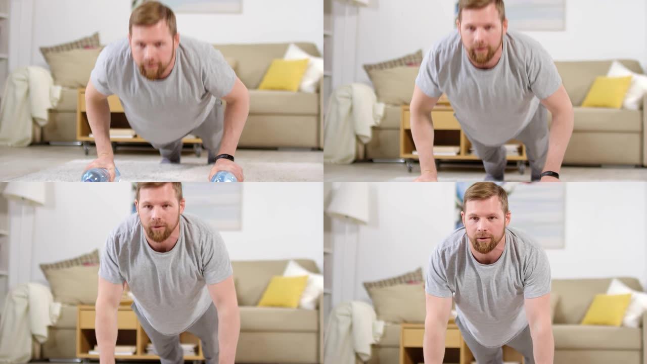 男子在家锻炼时用瓶装水做俯卧撑