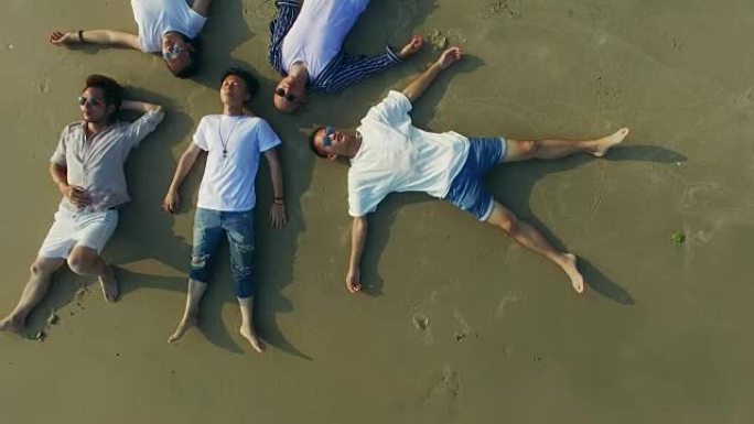 年轻的亚洲成年人躺在沙滩上闭着眼睛
