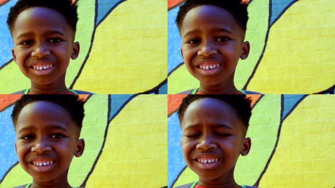快乐的非洲裔美国男生站在学校4k的墙上的前视图