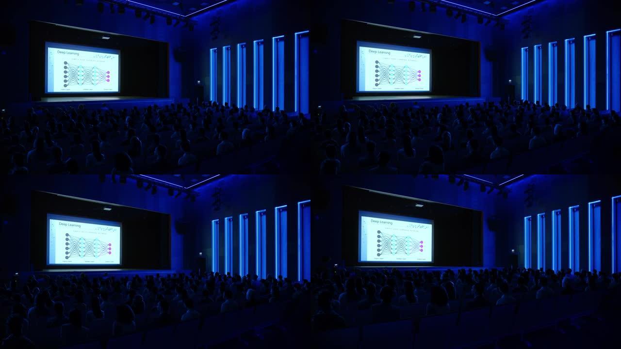 电影院里的技术人员在大屏幕上观看高科技新产品神经网络机器学习软件演示。科技产业商务会议礼堂大厅人满事