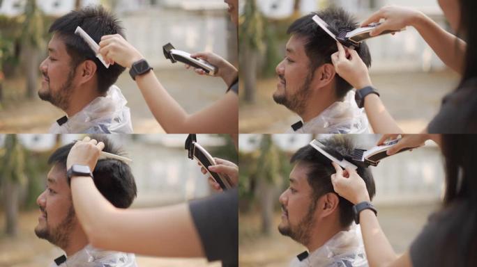 新型冠状病毒肺炎电晕病毒情况下亚洲男子在家被理发剪的侧视图