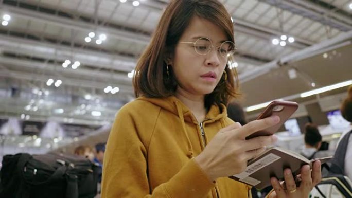 亚洲妇女在机场值机柜台办理登机手续