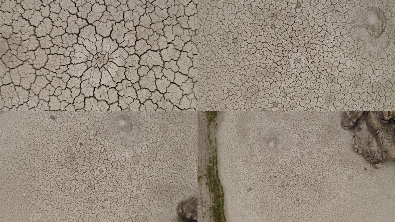 由于气候变化和全球变暖造成的干旱，4K空中缩小了死鱼躺在干燥大坝破裂的泥浆表面上的圆形视图