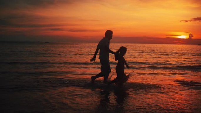 日落时分在沙滩上奔跑的SLO MO父女