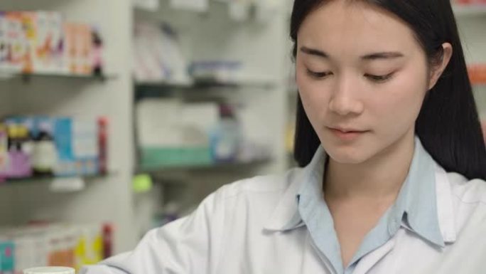 年轻的亚洲药剂师妇女数处方药。
