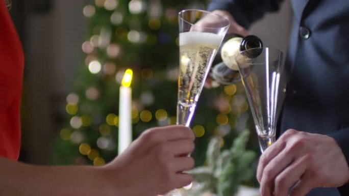 无法识别的男人在新年聚会上为女士倒香槟