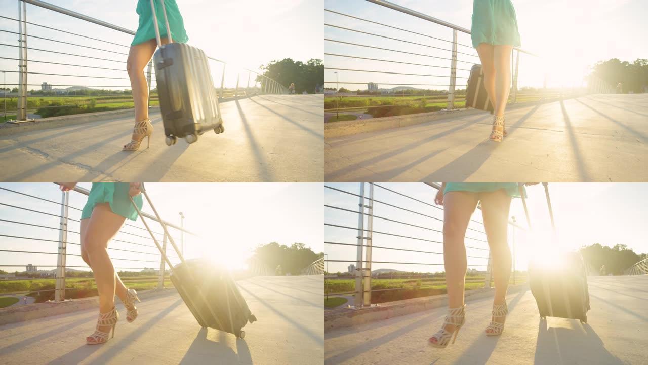 低角度: 快乐的女人在步行到机场时带着手提箱旋转。